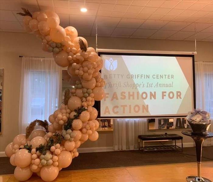 Balloon arch and screen saying Betty Griffin Center Thrift Shoppe's 1st Annual Fashion Show.